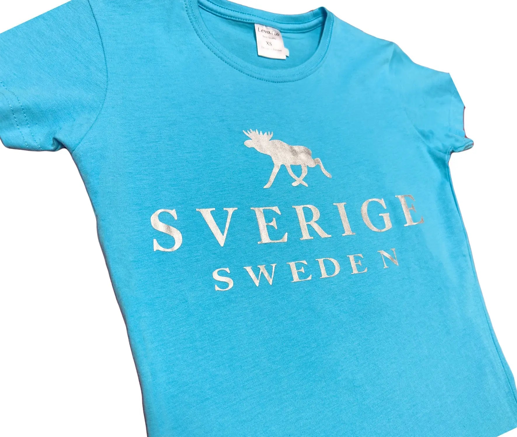 Close up view - Elegant Women’s t-shirt in sky blue with a shimmering silver moose graphic and bold “SVERIGE SWEDEN” text. - Style Council